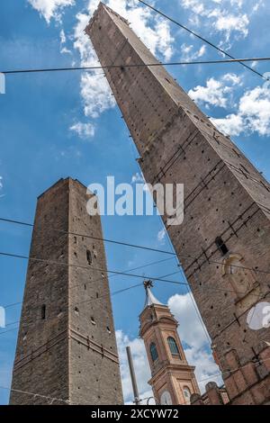 View from below of the two ancient towers of Asinelli and Garisenda with the bell tower of the Basilica of Santi Bartolomeo e Gaetano in the middle, B Stock Photo