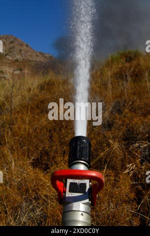 The fireman's hand holds a fire hose to extinguish a fire.Extinguish the fire. Fire hose Stock Photo