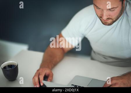 Laptop, coffee and man with research in office for online web development at startup tech company. Mouse, espresso and male programmer with computer Stock Photo