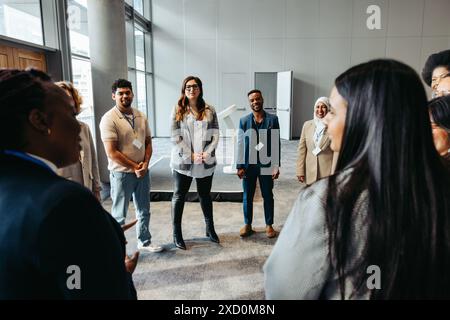 A diverse group of business professionals engaging in a team building discussion in a modern office setting. Collaborative and inclusive work environm Stock Photo
