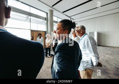 A diverse group of people gathering for a teambuilding workshop filled with fun exercises. They are smiling and engaging in a positive environment. Stock Photo