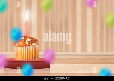 Birthday cupcake with burning candle on wooden background with colorful balloons. Copy space. Stock Photo