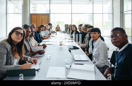 First person view showing a big team staff meeting in a modern conference room with diverse employees discussing and collaborating. Stock Photo
