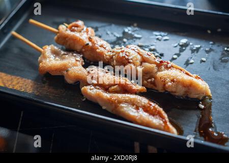 Nice view of Teriyaki chicken skewers on black plate and soy sauce Stock Photo