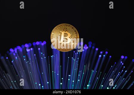Glowing Bitcoin cryptocurrency against the background of fiber optic cables. Bitcoin digital cryptocurrency consisting of dots and lines, cryptocurren Stock Photo
