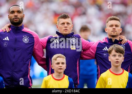 (Left to right) Germany's Jonathan Tah, Toni Kroos and Maximilian Mittelstadt during their side’s National Anthem before the UEFA Euro 2024 Group A match at the Stuttgart Arena in Stuttgart, Germany. Picture date: Wednesday June 19, 2024. Stock Photo