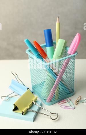 Holder and other different stationery on white table Stock Photo