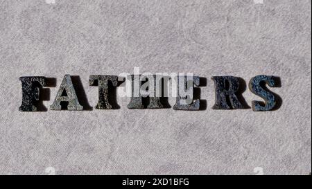 Lettering father in black letters on grey background on father's day close-up Stock Photo