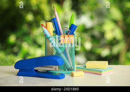 Stapler, holder and other different stationery on white table Stock Photo