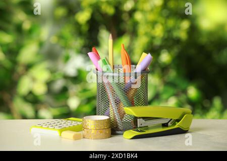 Stapler, holder and other different stationery on white table Stock Photo