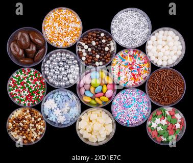 Colorful sugar and chocolate sprinkles, nonpareils in plastic cups, from above. Decoration and toppings in the shape of tiny pearls, snowflakes, etc. Stock Photo