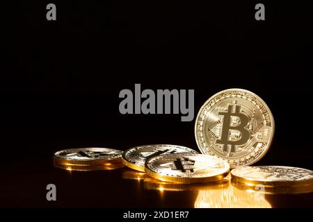 Bitcoin cryptocurrency gold coins on black background. Stock Photo