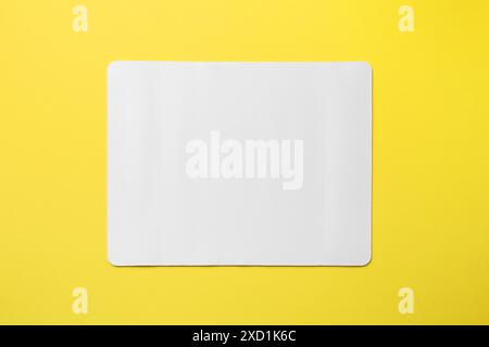 One white mouse pad on yellow background, top view. Space for text Stock Photo