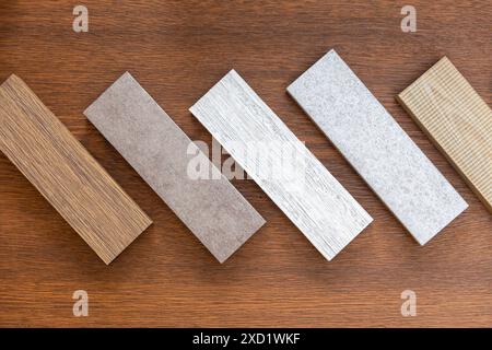 Assortment of baseboard molding and flooring samples in shop. Samples of skirting boards on wooden background. Stock Photo