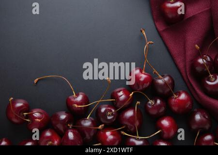 Close-up of fresh cherries with stems scattered on a dark background, burgundy color, elegant cherry background Stock Photo