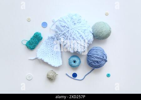 Yarn balls and buttons on white background Stock Photo