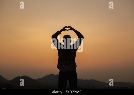 A young man uses sign language to express his love and friendship to his friend and lover. Sign language concept shows heart symbol to express love, f Stock Photo