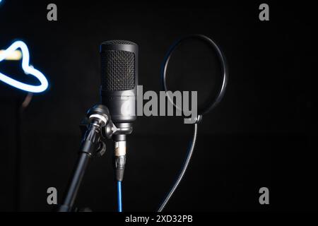 Close-up of a professional condenser studio microphone on a black background in a music studio. Stock Photo