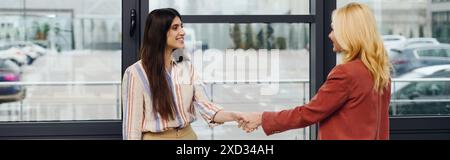 Two business women shaking hands in office after negotiations. Stock Photo