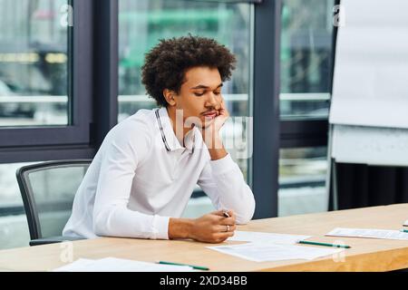 A man attentively sitting at desk in office. Stock Photo