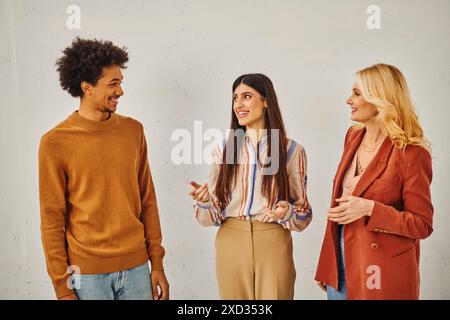 Three individuals engaging in conversation against a blank backdrop. Stock Photo
