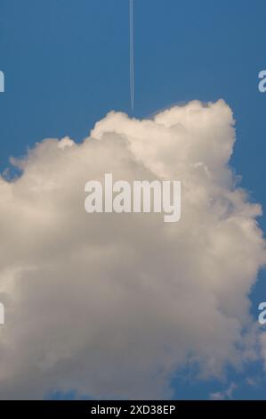 Conceptual Plane flying among white fluffy clouds Stock Photo
