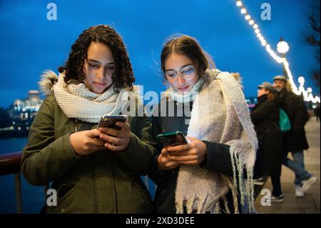 Young woman and man using smartphones on London evening. Stock Photo