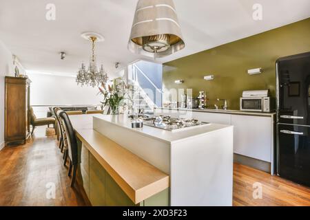 This tastefully designed kitchen features contemporary appliances, a luxurious chandelier, and a mix of classic and modern furnishings, located in Twe Stock Photo