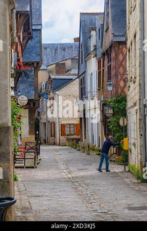 Man posting a letter in a yellow postbox in an medieval street in Chinon ,Loire Valley , France Stock Photo