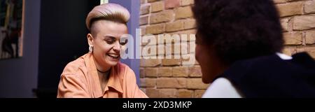 Two diverse women seated, engaged in conversation. Stock Photo