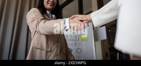 Professional Business Handshake Between Two Individuals in a Modern Office Setting Stock Photo