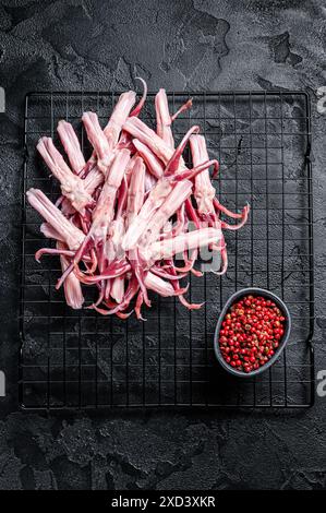 Raw Duck Tongue ready for cooking. Black background. Top view. Stock Photo