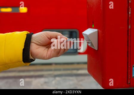traveler, woman validating train ticket at terminal, public ...
