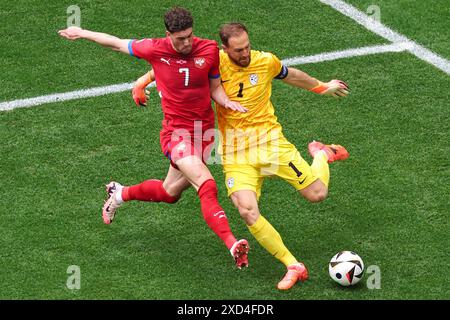 Munich, Germany. 20th June, 2024. Soccer: European Championship, Slovenia - Serbia, preliminary round, group C, match day 2, Munich Football Arena, Serbia's Dusan Vlahovic (l) and Slovenia's goalkeeper Jan Oblak fight for the ball. Credit: Daniel Karmann/dpa/Alamy Live News Stock Photo