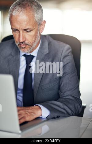 Mature businessman, typing and laptop in office for online research, writing email and project management. Senior guy, consultant and computer for Stock Photo