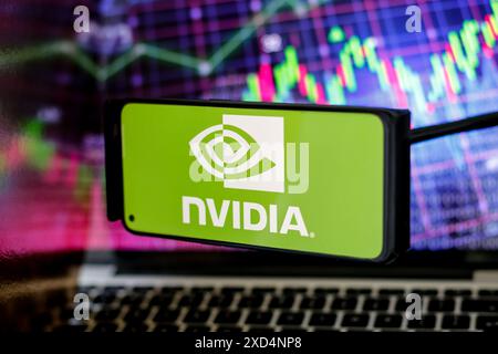 London, UK. 20th June, 2024. In this photo illustration, the Nvidia logo is seen displayed on a smartphone screen against a computer screen displaying a stock charts image, as stock value of the company has risen dramatically due to its sales of chps needed for AI development - June 20, 2024. (Photo by Dominika Zarzycka/Sipa USA) Credit: Sipa USA/Ģ����ý Live News Stock Photo