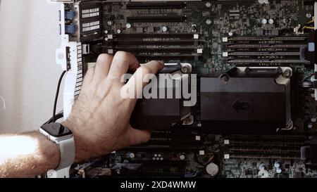 A man installing a second CPU in a powerful workstation for new AI and mathematical model generation, showcasing supercomputer servicing in a high-tech environment Stock Photo