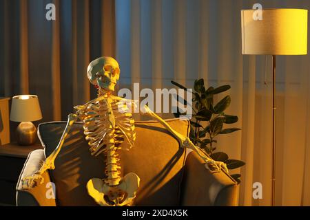 Waiting concept. Human skeleton sitting in armchair indoors Stock Photo