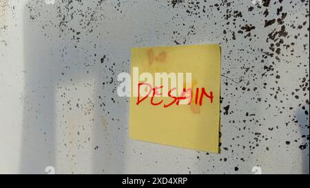 Text with the words "design" on a note pasted on the wall Stock Photo