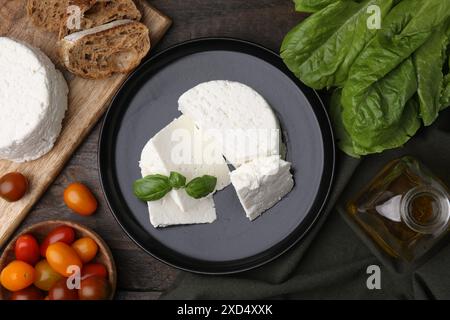 Fresh ricotta (cream cheese), basil and other products on wooden table, flat lay Stock Photo