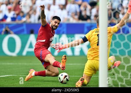 Munich, Germany. 20th June, 2024. Soccer: European Championship, Slovenia - Serbia, preliminary round, group C, match day 2, Munich Football Arena, Serbia's Aleksandar Mitrovic (l) and Slovenia's goalkeeper Jan Oblak fight for the ball. Credit: Peter Kneffel/dpa/Alamy Live News Stock Photo