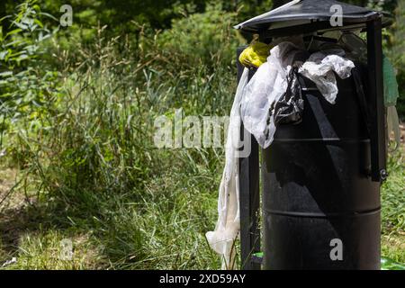 Overflowing Trash Can in Park Stock Photo