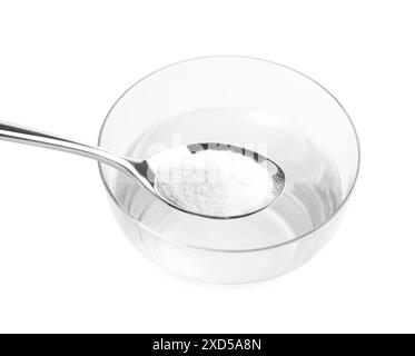 Spoon with baking soda over glass of water on light background, closeup Stock Photo