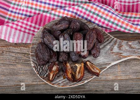 Large size Jerusalem Date fruit. Close up shot of date fruit on marble tray in silver bowl on wooden table background. Dried date fruit is healthy as Stock Photo
