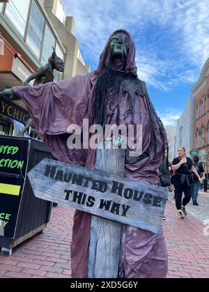 A ghoulish figure points visitors towards a haunted house attraction near Halloween on an autumn day in downtown Salem Massachusetts Stock Photo