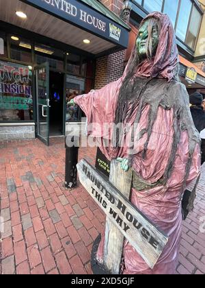 A ghoulish creature points the way to a haunted house attraction, hoping to lure tourists to the attraction in Salem Massachusetts Stock Photo