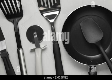 Different spatulas and other kitchen utensils on grey background, flat lay Stock Photo
