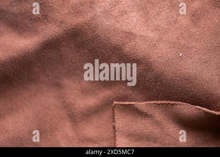 Close-up of brown fabric with visible texture and stitching. Stock Photo