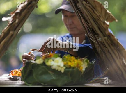 Chiang Mai, Thailand. 20th June, 2024. A Thai man prepares offerings during the festival. The festival is unique and not often witnessed by outsiders, but held annually in the foothills of Doi Kham Mountain, to pay homage to two ancient giant spirits, Pu Sae and Ya Sae. (Photo by Pongmanat Tasiri/SOPA Images/Sipa USA) Credit: Sipa USA/Alamy Live News Stock Photo