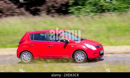 Milton Keynes,UK - June 20th 2024:  2012 red Hyundai i20 car driving on a British country road Stock Photo